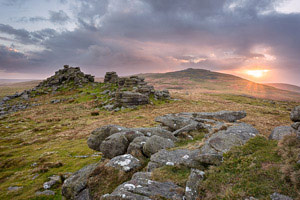 Sun peeks out from behind the clouds over West Mill Tor, Dartmoor